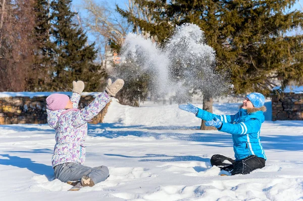 Портрет на улице. Две молодые счастливые девушки рвут снег. Забрасывали снежками, играли в зимнем парке — стоковое фото