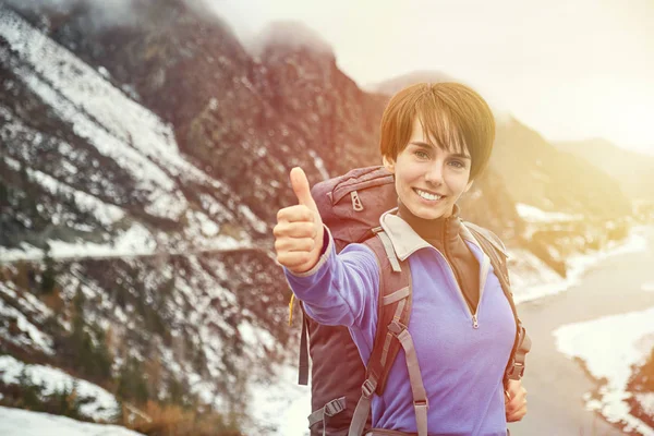 Senderismo mujer sonriente con una mochila en las montañas. Hermosa joven está viajando en las montañas — Foto de Stock