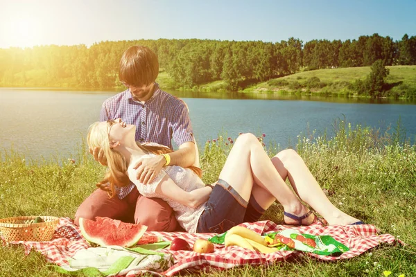 Casal apaixonado em um piquenique no lago — Fotografia de Stock