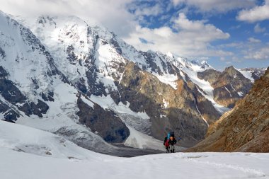 Bir grup dağcı karlı bir dağın tepesine tırmanır.