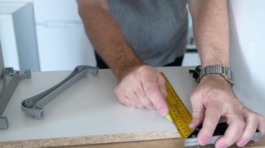 marangoz, bant ölçüsü ve kalem ile lamine detayları işaretliyor