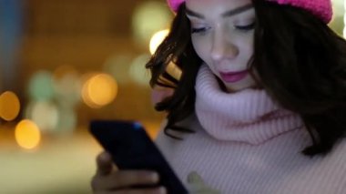 Cep telefonu şehirde geceleri kullanan genç güzel kadın.