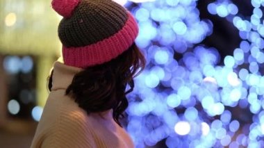 Noel 'de çelenklerle ve bayram ışıklarıyla gülümseyen kadın