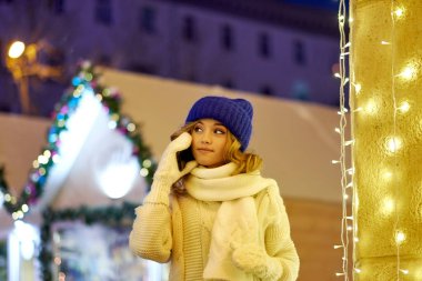 Noel 'de ya da yeni yılda tebrik etmek için arayan bir kadın. Festival fuarında akıllı telefonu olan bir kadın.