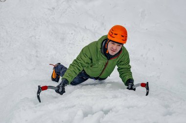 Alpinist adam buz araçları balta bir lar tırmanma turuncu kask içinde