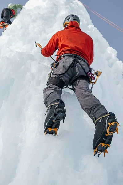 Αλπινιστής άνθρωπος με εργαλεία πάγου τσεκούρι αναρρίχηση σε ένα μεγάλο τοίχο του πάγου. Ου. — Φωτογραφία Αρχείου