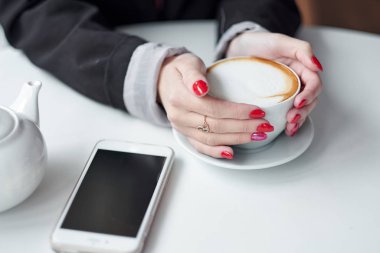 Kadın el ve akıllı telefon ve kahve