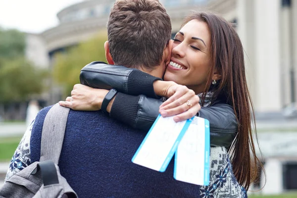 Happy cheerful couple hugging and showing flying tickets. man making a surprise to a woman - giving tickets for a honeymoon — Stock Photo, Image