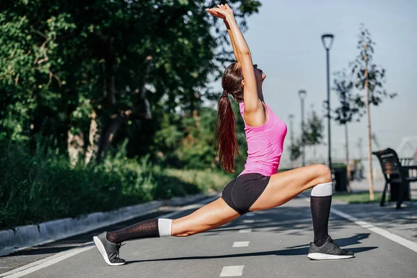 Fitness jovem mulher esticando as pernas após a corrida. ao ar livre retrato esporte — Fotografia de Stock