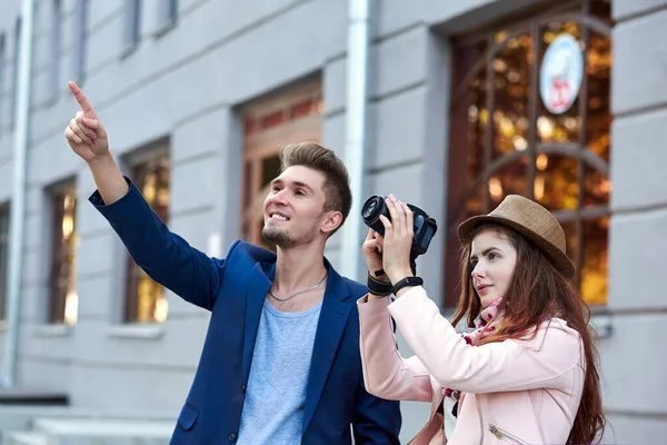 Amor feliz pareja de turistas tomando fotos en excursión o tour por la ciudad. Fotos sobre el fondo de la arquitectura urbana —  Fotos de Stock