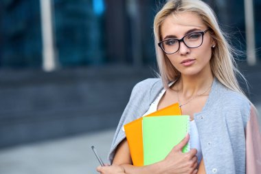 Ofis binasında dosyası olan mutlu genç bir iş kadını..