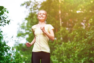 Yaz parkında atletik atletizm antrenmanları yapan bir kadın. Açık hava fitness portresi