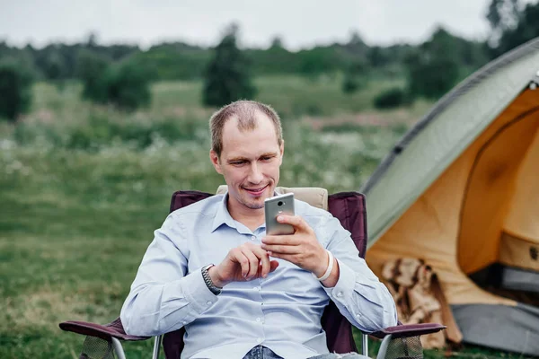 Giovane Freelance Seduto Sulla Sedia Utilizzando Smartphone Rilassarsi Davanti Alla — Foto Stock