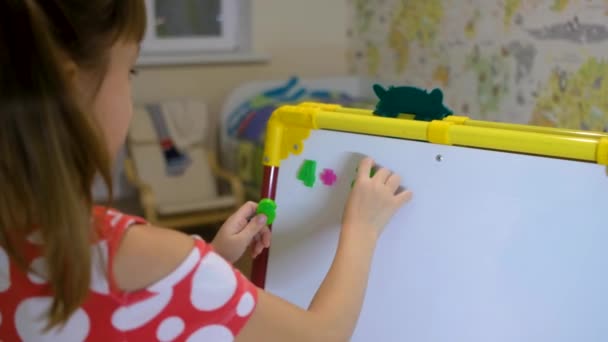 Menina usando placa ímã para aprender letras e números em casa — Vídeo de Stock