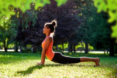 Yoga. Yoga yapan, dans eden ya da parkta esneme hareketleri yapan genç bir kadın. Sağlık yaşam tarzı kavramı.
