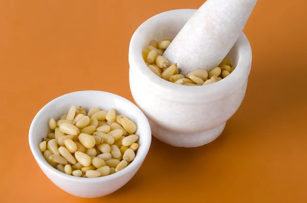 Pine nuts in bowl and mortar — Stock Photo, Image