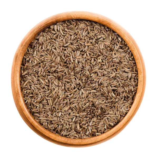 Caraway seeds in a wooden bowl over white — Stock Photo, Image