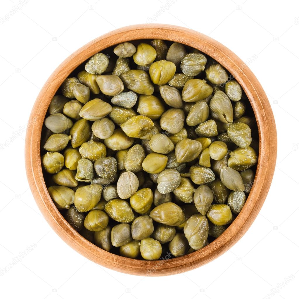 Capers in wooden bowl on white background