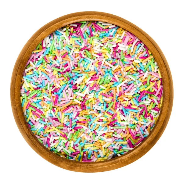 Kropi kolorowe cukier do dekoracji żywności w drewniana miska na białym tle. Multi kolorowe składnik ozdoba piekarnia, używane do ciast i ciasteczek. Fotografia jedzenie makro na białym tle z bliska z góry. — Zdjęcie stockowe