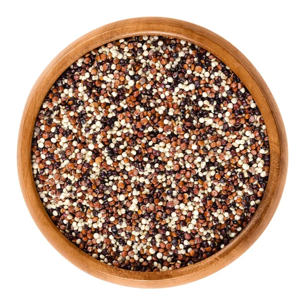 Смешанные семена киноа в деревянной чаше поверх белого — стоковое фото