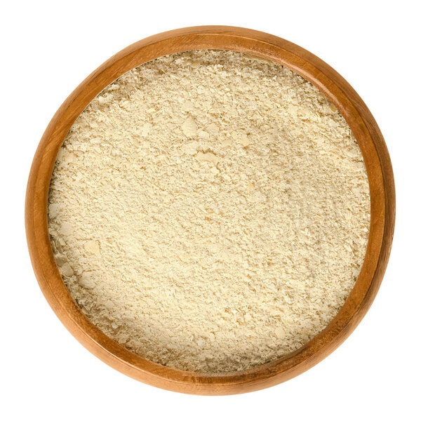 Питательные хлопья дрожжей в деревянной чаше над белым
