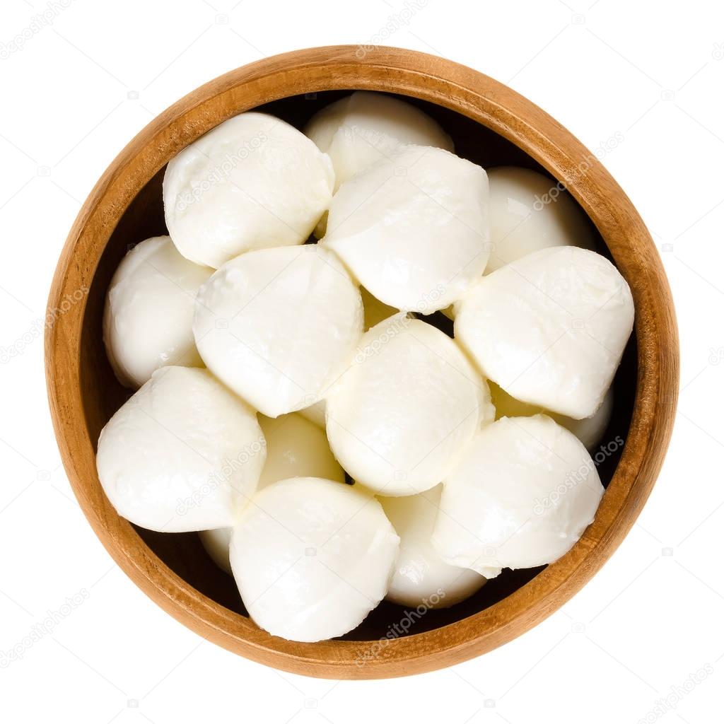 Bambini mozzarella in wooden bowl over white