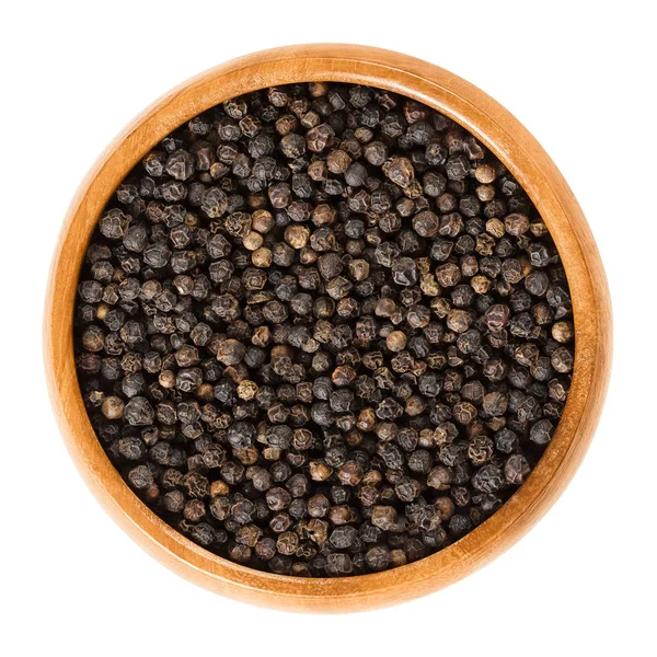 Black pepper in wooden bowl over white — Stock Photo, Image