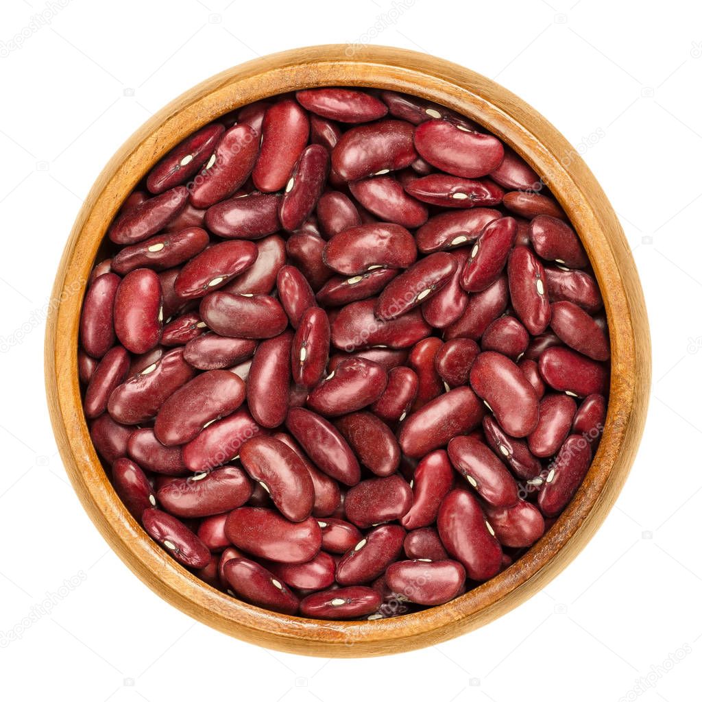 Dried red kidney beans in wooden bowl over white