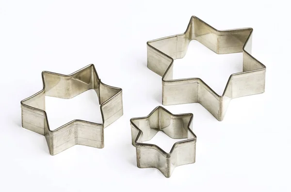 Three star shaped Christmas cookie cutters over white — Stock Photo, Image