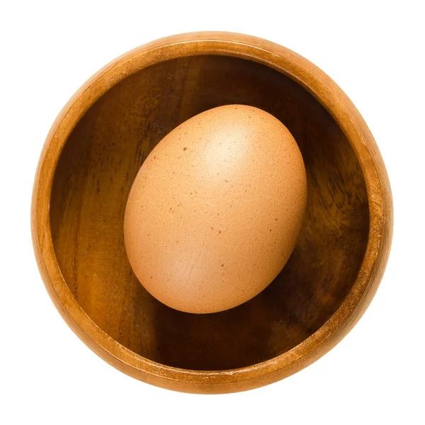 Œuf de poulet entier dans un bol en bois sur blanc — Photo