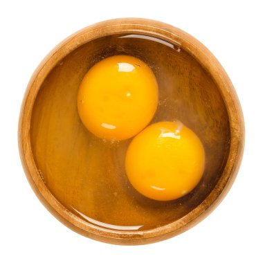 İki çiğ tavuk yumurtası ahşap bir kasenin içine kırık