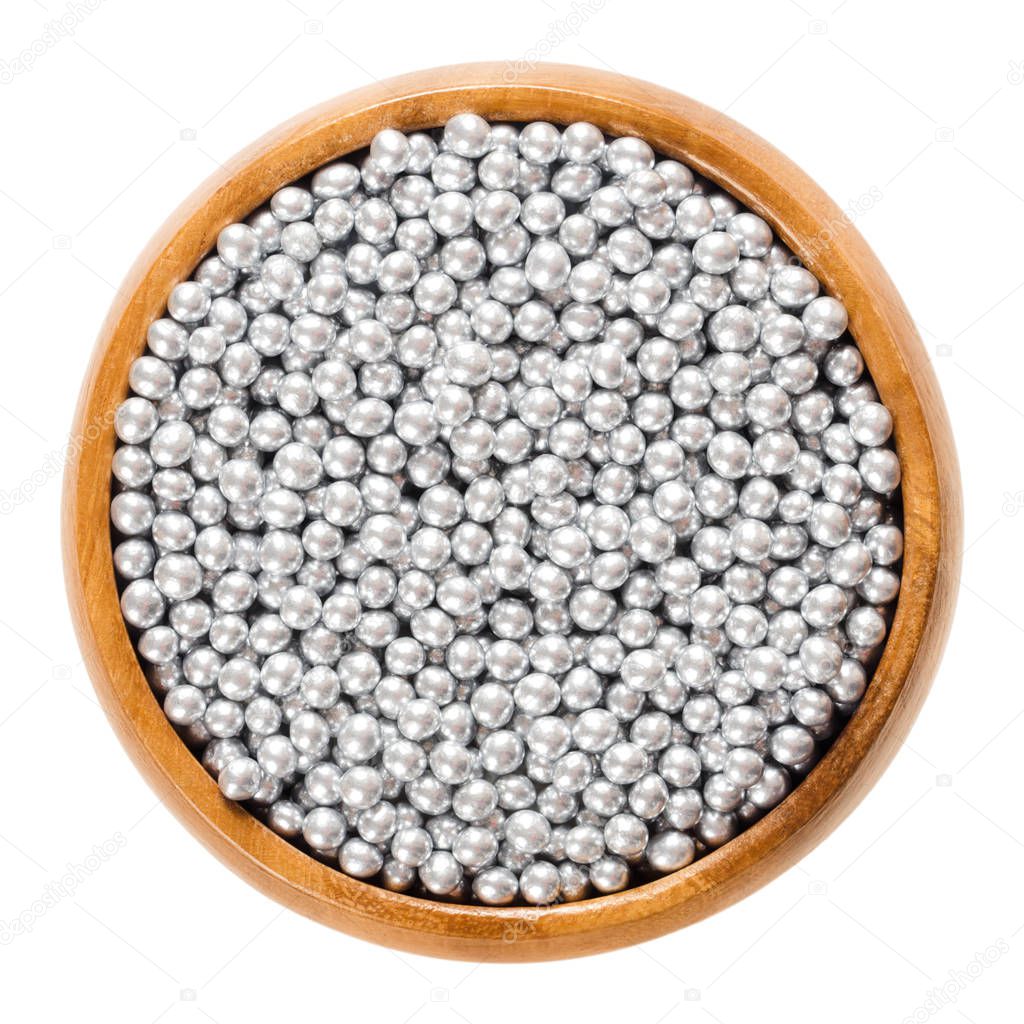 Silver nonpareils in wooden bowl over white