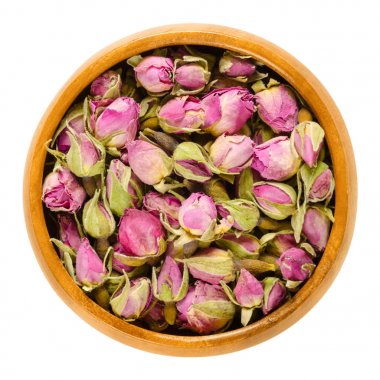 Ahşap kase gül tomurcukları kurutulmuş. Çiçekli bitki cinsi Rosa. Dekorasyon, koku gibi çaylar ve perfums için kullanılır. İzole makro gıda fotoğraf yakın çekim yukarıdan beyaz arka plan üzerinde.