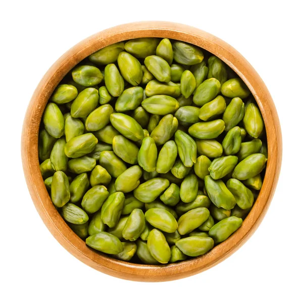 Green pistachio seeds in wooden bowl over white — Stock Photo, Image