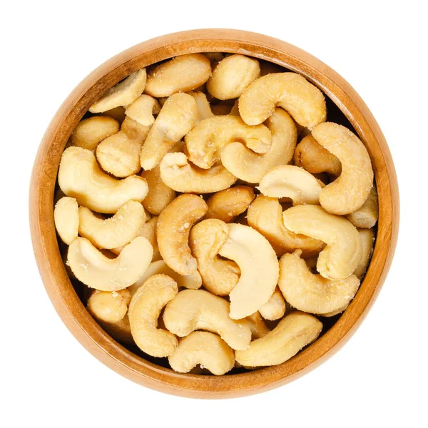 Roasted salted whole cashews in wooden bowl over white — Stock Photo, Image