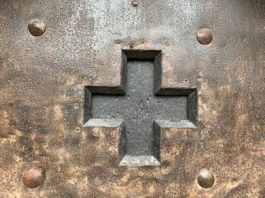 Demir bir kapının içinde siyah bir haç kesmişler.