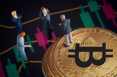 Makro minyatür işadamı figürü altın bitcoin yığınının üzerinde duruyor ve diğer iş adamlarıyla konuşuyor. Arkaplanda borsa grafikleri var. Geleceğin para birimi ve engel zinciri konseptiyle ilgili iş toplantısı.