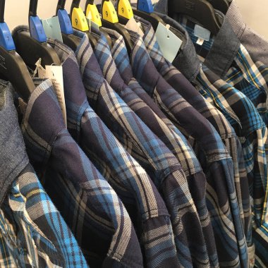 Giysiler tasarımcı giyim mağazasının rafında asılı.