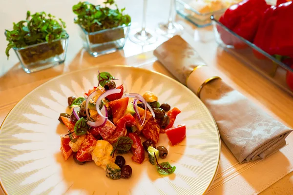 Greek salad. Salad next to the ingredients used. Recipes Tasty food. Concept - do-it-yourself cooking. Healthy food restaurant. Greek salad in a big plate. Napkin. Fresh vegetables. Lettuce leaf