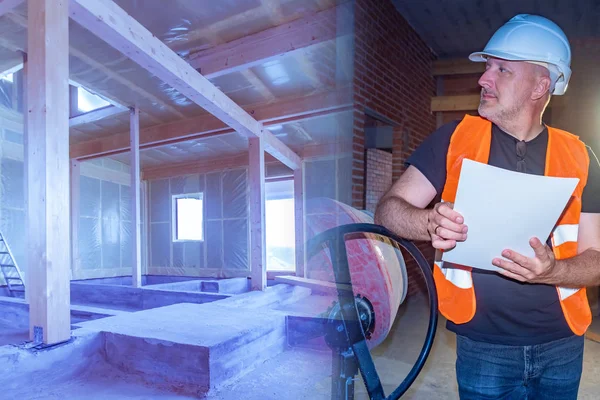 An engineer with drawings in hand controls the progress of const