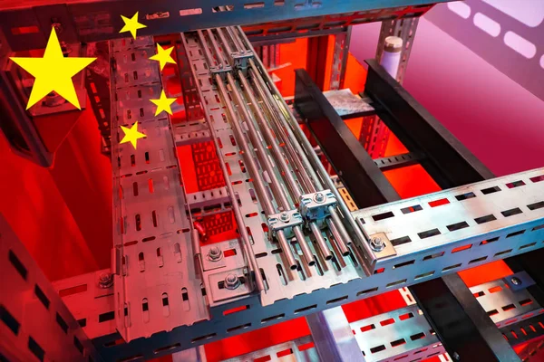 Production of electrical equipment in China. Chinese industrial concept. Metal boxes for wires on the background of the Chinese flag. Supplies of electrical installation equipment from China.