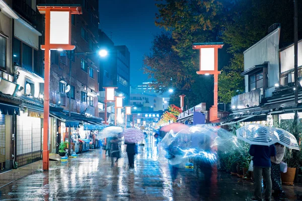 Japan.Tokyo. Rainy evening in Tokyo. People walk with umbrellas on the Japanese street. Rain in Japan. Rainy weather. Life in the big city.