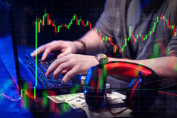 A person works at a computer against the background of quotations of securities and money. Stockbroker at work. Bids or asks. The bulls and the bears. Exchange strategies. Receiving income or losses.
