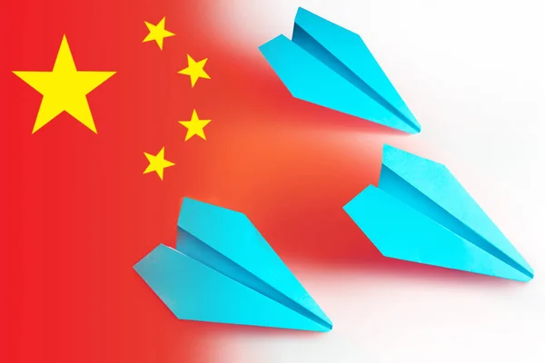 Three paper airplanes on the background of the Chinese flag. Flights from the Republic of China. Tourism in China. Travel of Chinese tourists. Trips to PRC. Chinese airline.