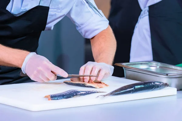 Butchering fish. Cook separates the bones from the fish. Selling fish fillets. Seafood shop. Restaurant specializing in seafood. Chef's career. Organization of the kitchen in the restaurant. Clean