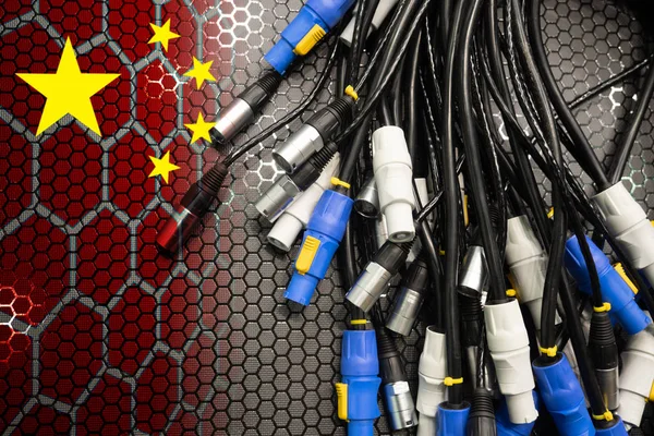 Wires with connectors and a Chinese flag. The concept of industrial China. The production of electrical goods on enterprises in China. Supplies of electrical equipment from China.