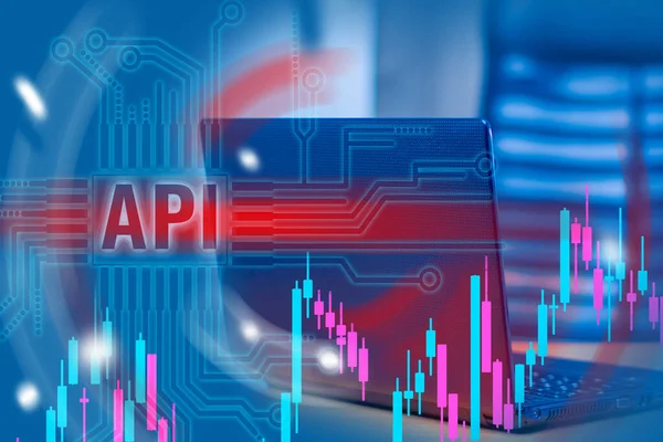 Work with the API. API logo on the background of the laptop. Concept - career programmer. Work in a web studio. Workplace web programmer. Charts as a symbol of financial app. Application programming