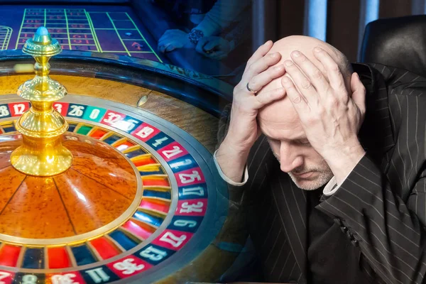 Depressed person and a view of the casino. The man clutched his head against the background of the roulette wheel. Losing at the casino. Lose money at the casino. Gambling. Cash game.