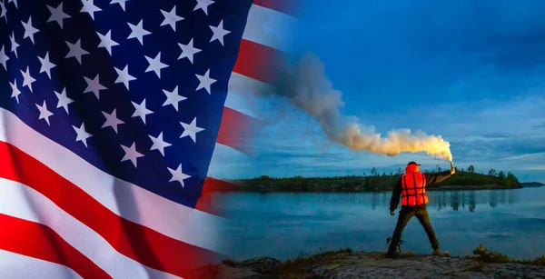 Symbol of salvation. Call for help. Saving the United States economy. A man waves a smoke bomb, calling for help. A man with a smoke bomb on the background of the us flag.