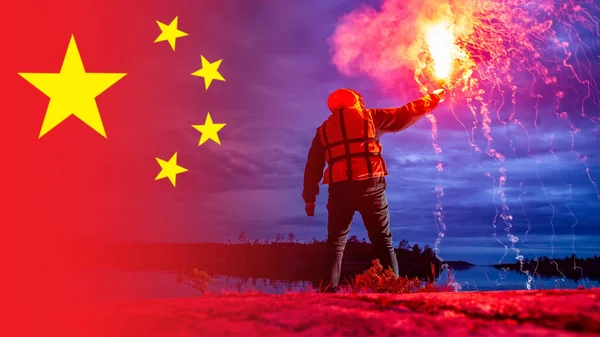 A man gives a signal of SOS. Concept - China sends a signal for help. A man next to the flag of China. The People\'s Republic of China gives a distress signal. Concept - call for help.